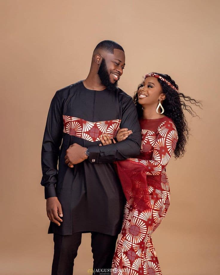 A smiling couple in coordinated outfits, arm in arm